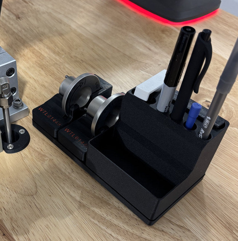 Black bench holder with pockets for pens and an open front compartment beside a metal work fixture