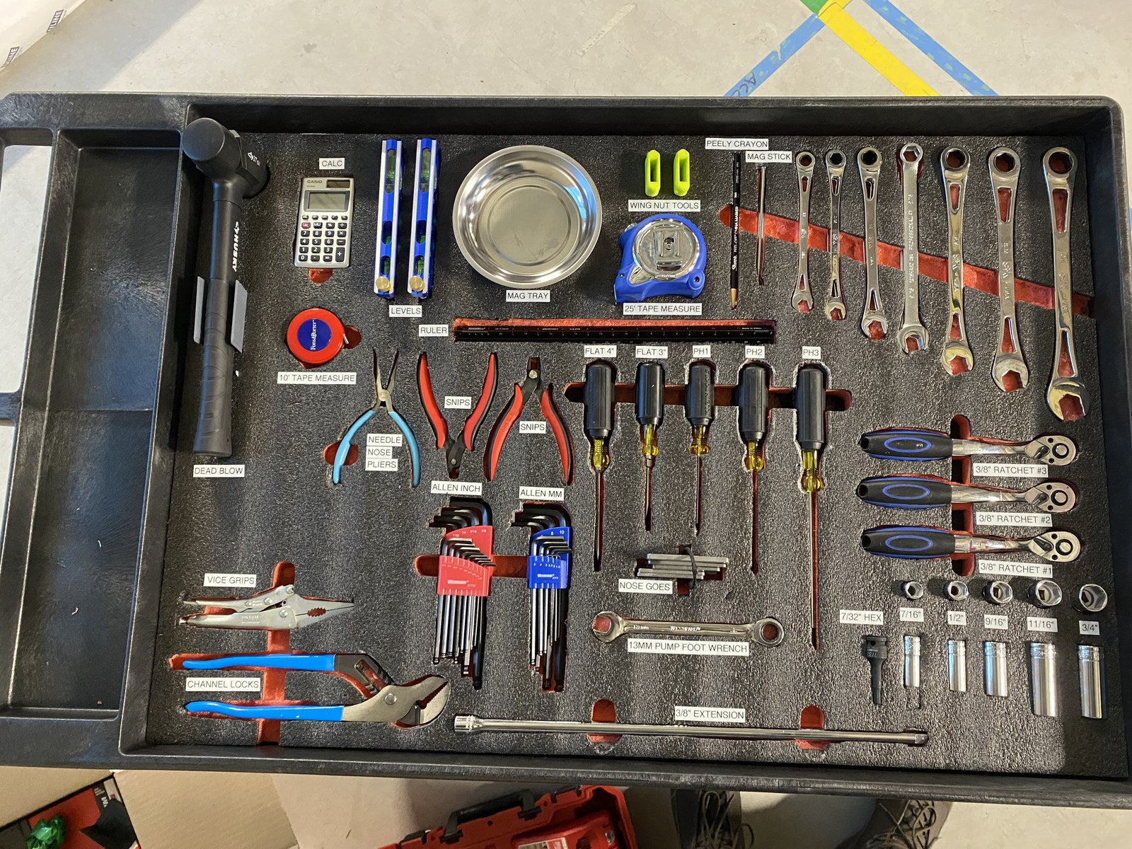 Open tool drawer with labeled foam cutouts for wrenches, drivers, and pliers