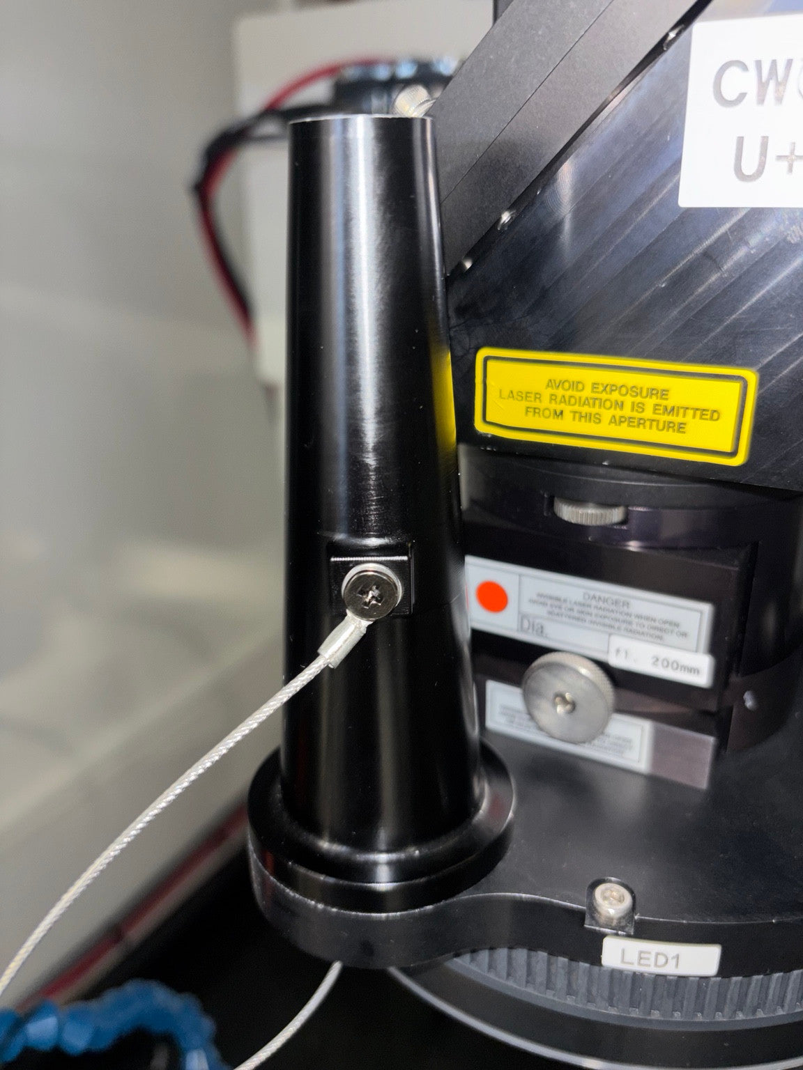 Closer photograph of the original black nozzle, its side screw and cable, and the lower mounting area