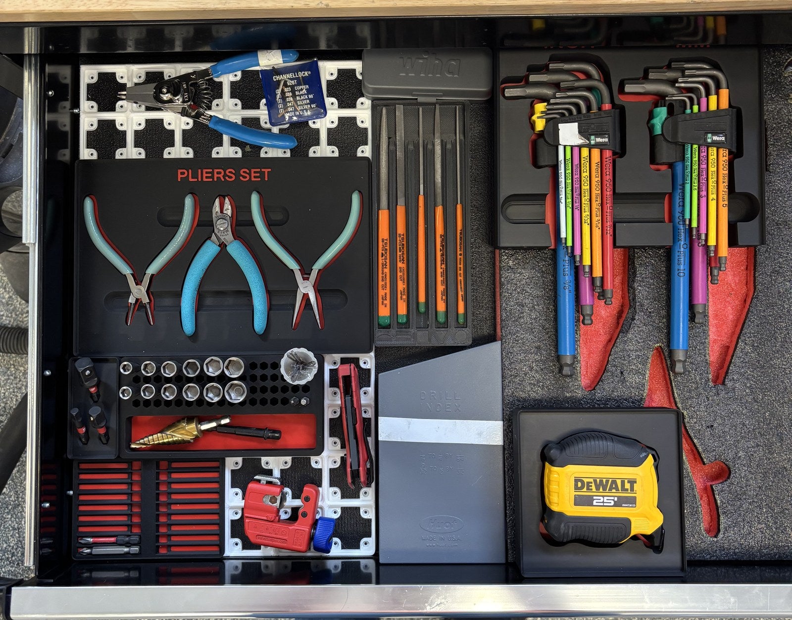 Open drawer with printed organizers for pliers, sockets, bits, and measuring tools